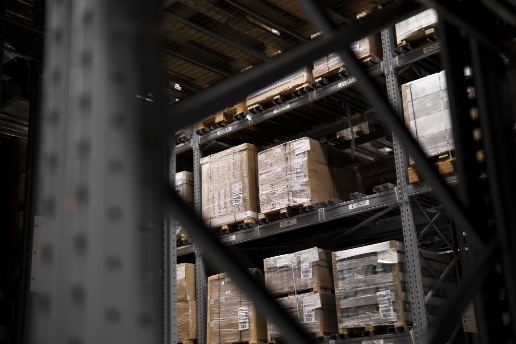 Palletized cartons on warehouse racking, with shipping labels and bin location codes